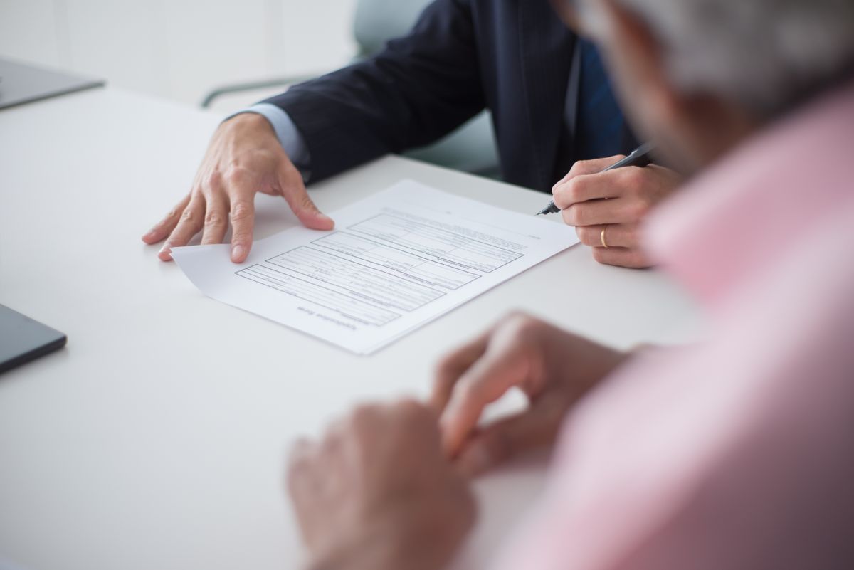 Two professionals reviewing and signing business documents together