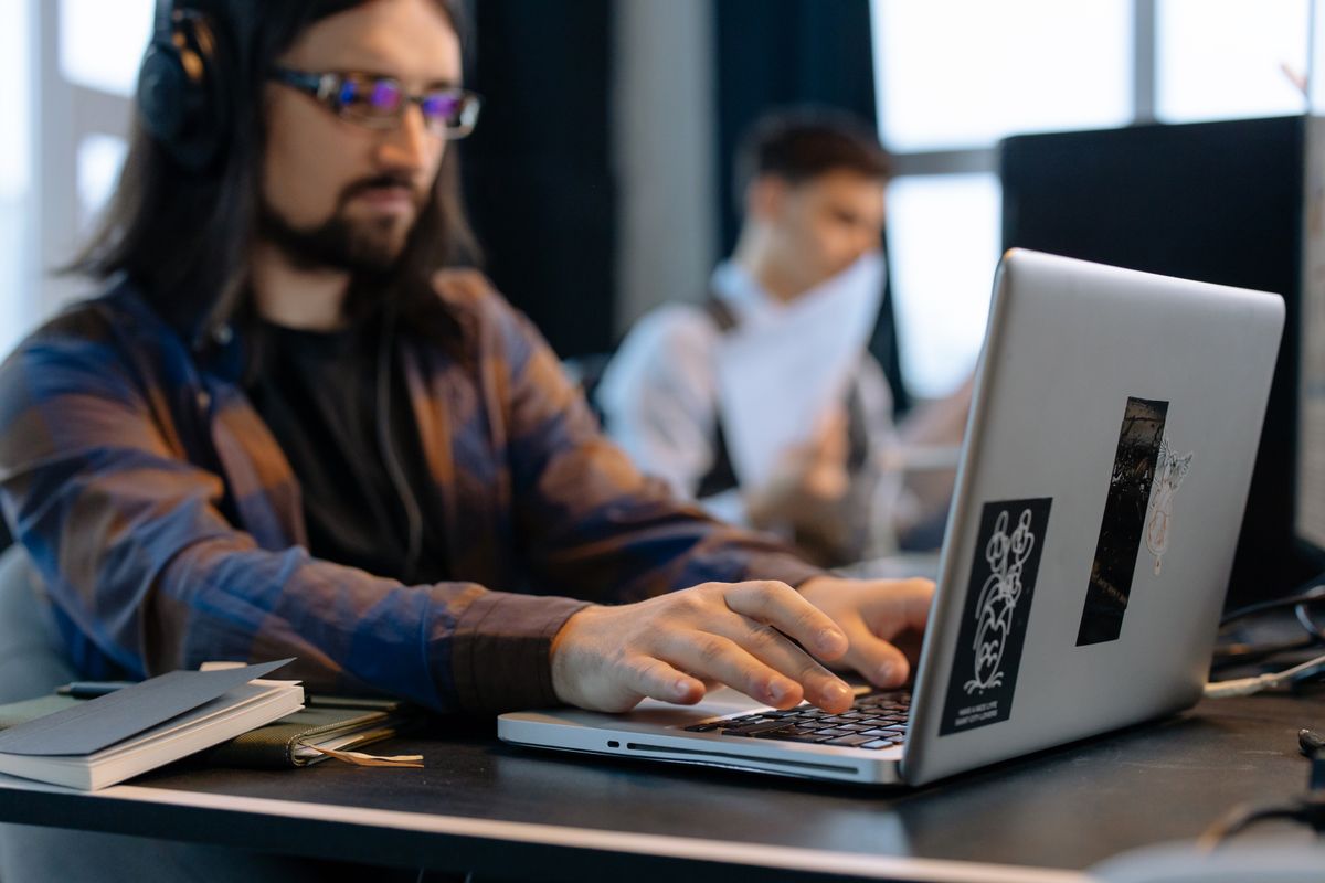 A developer working on a laptop beside an office window